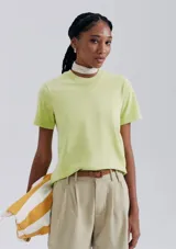 Remera color beige de corte clásico, con cuello redondo y mangas cortas.