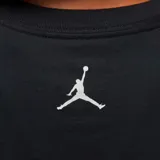 Camiseta negra de algodón con cuello redondo y manga corta. Estampado frontal con el logo de Jordan en color crema y efecto de movimiento.