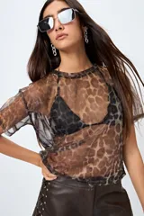 Top translúcido de manga corta con estampado animal print y tejido liviano con sutil brillo metálico. Ideal para superponer sobre tops al tono o lencería visible.