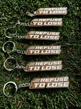 Llavero 3D de plástico PLA color beige con la frase "Refuse to Lose" en letras blancas.