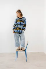 Buzo tejido jacquard con diseño de langostas, corte oversized y tajos laterales.