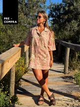 Camisa oversize de manga corta con cuello camisero y botones frontales. Confeccionada en tejido estampado con motivos marinos y texto en tonos rosados y beige.