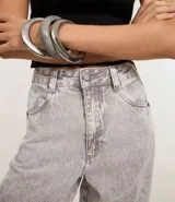 Pantalón de mujer wide leg en jeans de algodón, color celeste claro con efecto lavado. Presenta talle alto con trabillas, cierre de botón y cremallera, bolsillos delanteros y traseros, un bolsillo cargo lateral y un recorte transversal en la pierna.