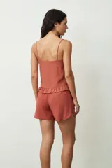 Short negro de tiro alto con cordón ajustable en la cintura y bolsillos laterales. Presenta un corte holgado y ruedos redondeados.