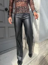 Pantalón negro de eco cuero, de tiro alto y corte recto.