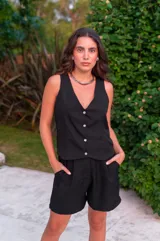 Conjunto de dos piezas color negro, compuesto por un chaleco con escote en V y botones al frente, y un short tipo bermuda con bolsillos laterales.