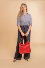 Cartera bandolera color marrón claro, de símil cuero, con dos divisiones internas, asa corta fija y correa larga regulable.