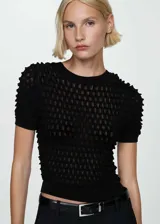 Buzo de punto fino negro con textura, cuello redondo y mangas cortas abullonadas. Diseño entallado.