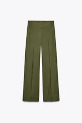 Pantalón color beige de lino, de tiro alto con cintura elástica, bolsillos laterales ocultos en costura y pernera ancha.