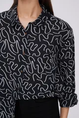 Camisa de manga larga negra con estampado de líneas blancas.