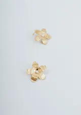 Par de aros dorados con forma de flor y una perla en el centro.