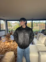 Chaqueta negra con logo bordado en blanco en la espalda.