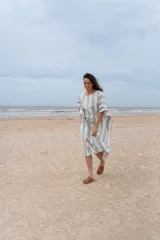 Túnica a rayas verticales anchas color gris y blanco, con mangas cortas y lazo en la cintura.