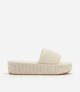 Sandalia flatform con superficie trenzada metalizada color dorado, sin cierre, con tira ancha y puntera redonda.