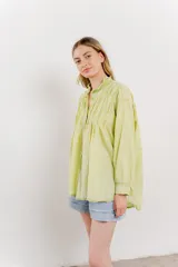 Camisa oversize de algodón color verde lima, con cuello mao con volados y pliegues verticales en el frente.