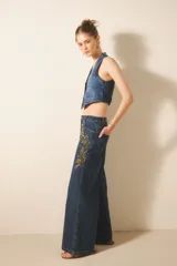 Pantalón oxford de denim azul con bordado de mostacillas y lentejuelas.