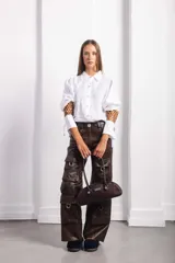 Cartera baguette negra con textura símil cuero de reptil, doble asa corta y logo metálico plateado de la marca Agnes.