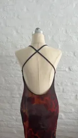 Vestido largo de microtul con estampado abstracto en tonos marrones, azules y naranjas. Tiene escote en V con encaje negro y breteles finos.