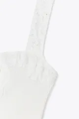 Top blanco de tejido de canalé, con escote recto y tirantes anchos con detalle de encaje.