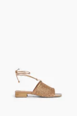 Sandalias bajas color cobre con capellada tejida y tiras finas para atar al tobillo.