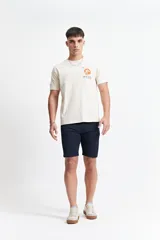 Remera color crema de manga corta con cuello redondo y estampado de una ola estilo Hokusai enmarcada en un rectángulo.