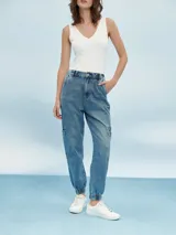 Pantalón de jean azul de corte cargo, con cintura alta y tobillos ajustados con elástico.