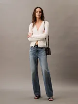 Remera blanca de punto acanalado con cuello en V y mangas largas. Corte ajustado al cuerpo.