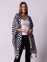 Kimono tejido con estampado geométrico en blanco y negro, con terminación de ruedo con borlas.