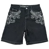 Bermuda de denim negro con bordados blancos estilo barroco/rococó en los bolsillos traseros y a lo largo de los costados. Presenta costuras contrastantes blancas, tiro medio y calce holgado (baggy fit). En la parte superior trasera lleva un aplique con el texto "Urban Coutur".