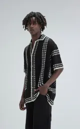 Camisa de manga corta tejida a crochet, color negro con detalles en blanco, de corte oversize.