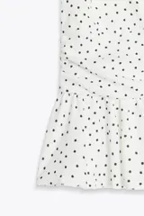 Top negro de cuello halter y escote pico con volantes en el bajo.
