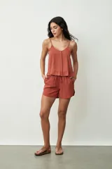 Short negro de tiro alto con cordón ajustable en la cintura y bolsillos laterales. Presenta un corte holgado y ruedos redondeados.