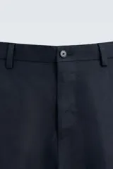 Pantalón de vestir color beige claro, confeccionado en lino, de corte recto, con bolsillos laterales y traseros.