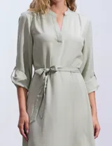 Vestido maxi color beige, con cuello mao, mangas 3/4 con presilla y lazo en la cintura.
