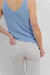 Pantalón jean de tiro alto, corte recto, cinco bolsillos, cierre frontal con cremallera y botón.