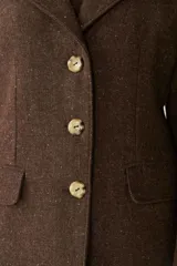 Tapado marrón de lana con cuello con solapa, manga larga, forrado, con bolsillos y cierre frontal con botones.