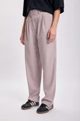 Pantalón de vestir color visón, de corte carrot, con pinzas en la cintura y bolsillos laterales.