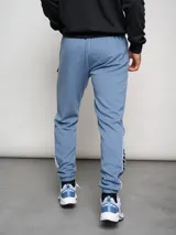 Pantalón de jogging negro con puños ajustados, cortes laterales y cambio de color en la parte inferior de la pierna.
