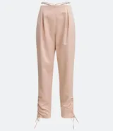 Pantalón jogger color beige de satín, con cintura elástica y lazos ajustables en los tobillos.