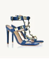 Sandalias de tacón alto color azul con textura de piel de serpiente y apliques de tachas piramidales doradas.