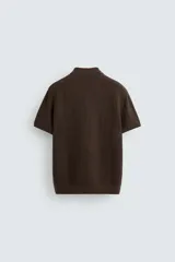 Polo gris de punto con textura, corte regular fit, cuello solapa y cierre frontal con botones.