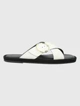 Sandalias de cuero sintético color blanco, con dos tiras anchas cruzadas sobre el empeine y hebilla circular dorada. Plataforma plana color negro.