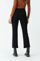 Pantalón de pana negro, de corte recto y tiro medio, con bolsillos y presillas para cinturón.