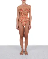 Traje de baño entero con estampado floral en tonos naranja, marrón y amarillo. Presenta escote pronunciado con tiras cruzadas y volados en los hombros.