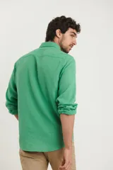 Camisa azul marino de lino y algodón, con cuello abotonado, manga larga con puños enrollados, bolsillo de parche en el pecho y cierre frontal con botones.