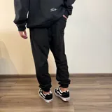 Pantalón de jogging negro con puños y estampado frontal con la leyenda "Buena Vibra Est. 2018".