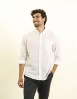 Camisa azul marino de lino y algodón, con cuello abotonado, manga larga con puños enrollados, bolsillo de parche en el pecho y cierre frontal con botones.