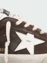 Championes Golden Goose modelo Super Star, color marrón de gamuza, con estrella blanca en el lateral y detalles en blanco en el talón.