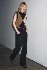 Pantalón de jean negro de corte palazzo, tiro medio y cintura con trabillas. Tiene bolsillos delanteros y traseros, raya planchada en el frente y cierre frontal con cremallera, botón y ganchos metálicos.