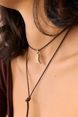 Dije dorado con forma de bota cowboy con detalles calados.